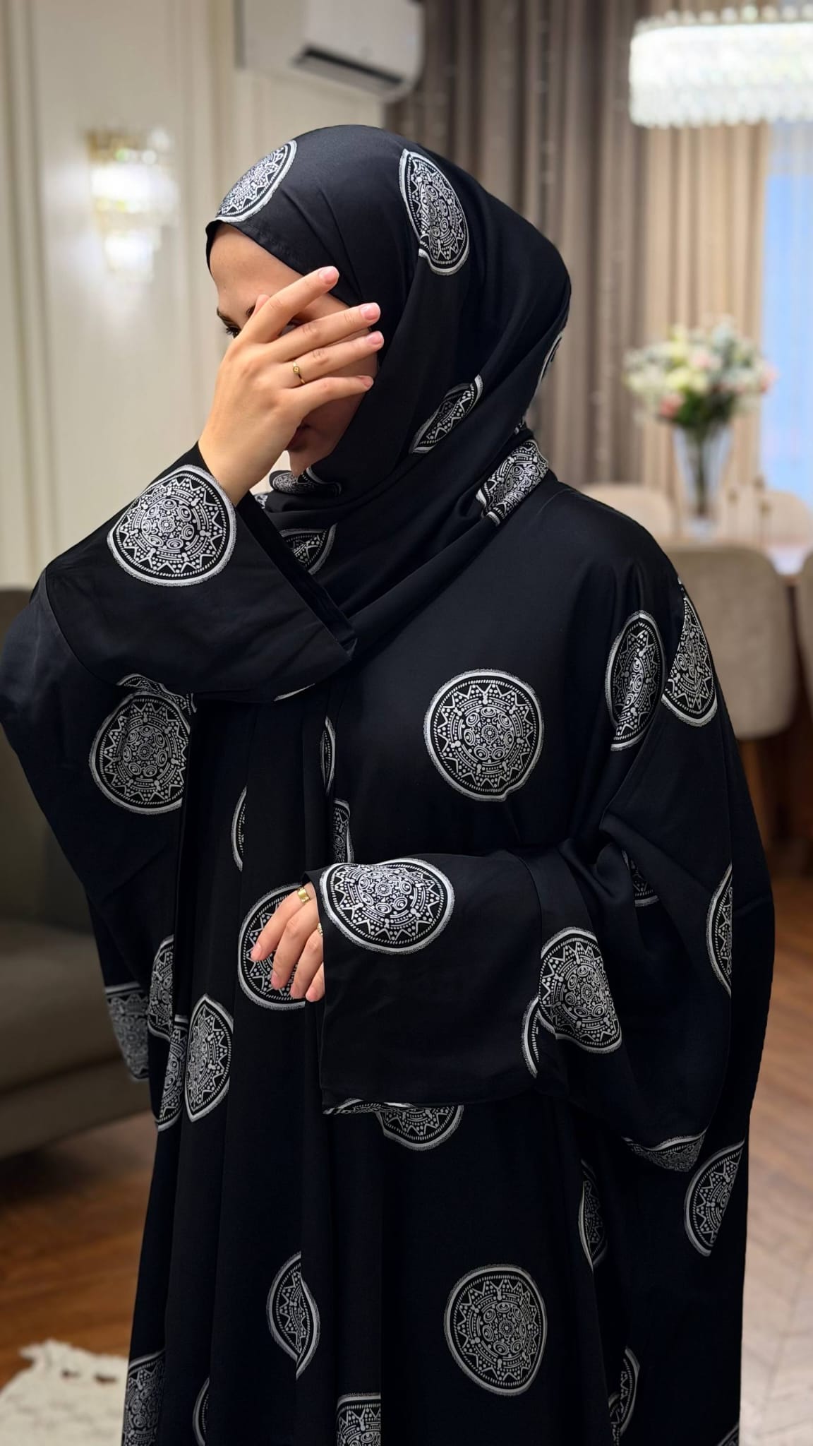 Schwarze Butterfly Abaya Mahira mit silberfarbenen runden Ornamenten, weitem Ärmel und passendem Hijab.