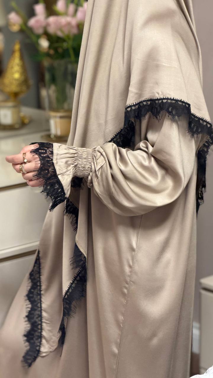 Detail der goldenen Dhahabiya Abaya aus Viskose mit eleganter schwarzer Spitze