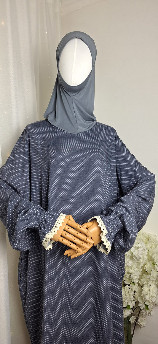 Seitenansicht des Gebetskleids Hafsa in Grau mit angenähtem Bonnet und Spitzenärmeln.
